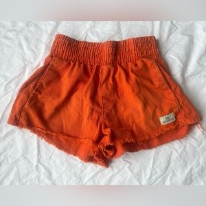 High waisted orange shorts.